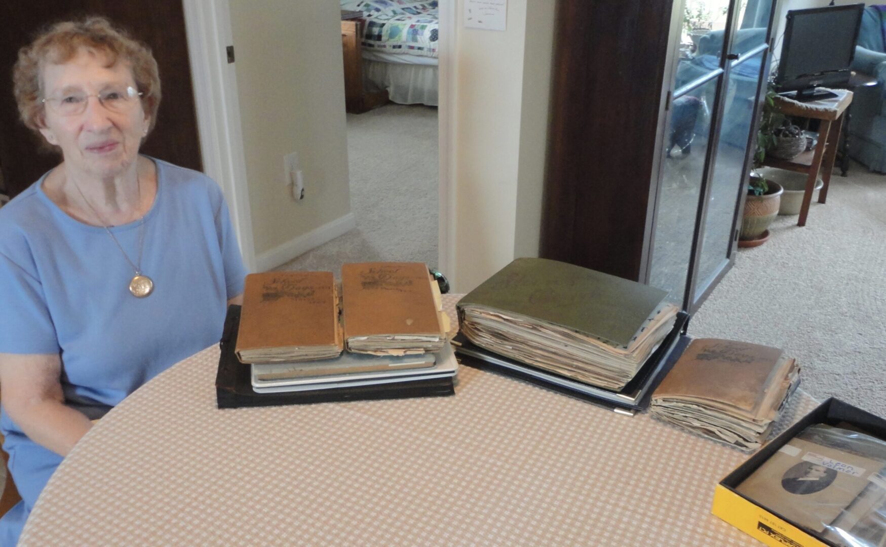 Liz Crosby with scrapbooks kept by her mother, Louise Volmer Sloane